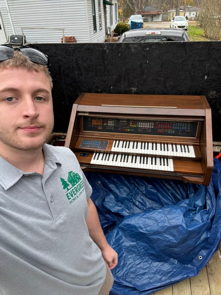 Crew removing vintage organ from estate — large item hauling included