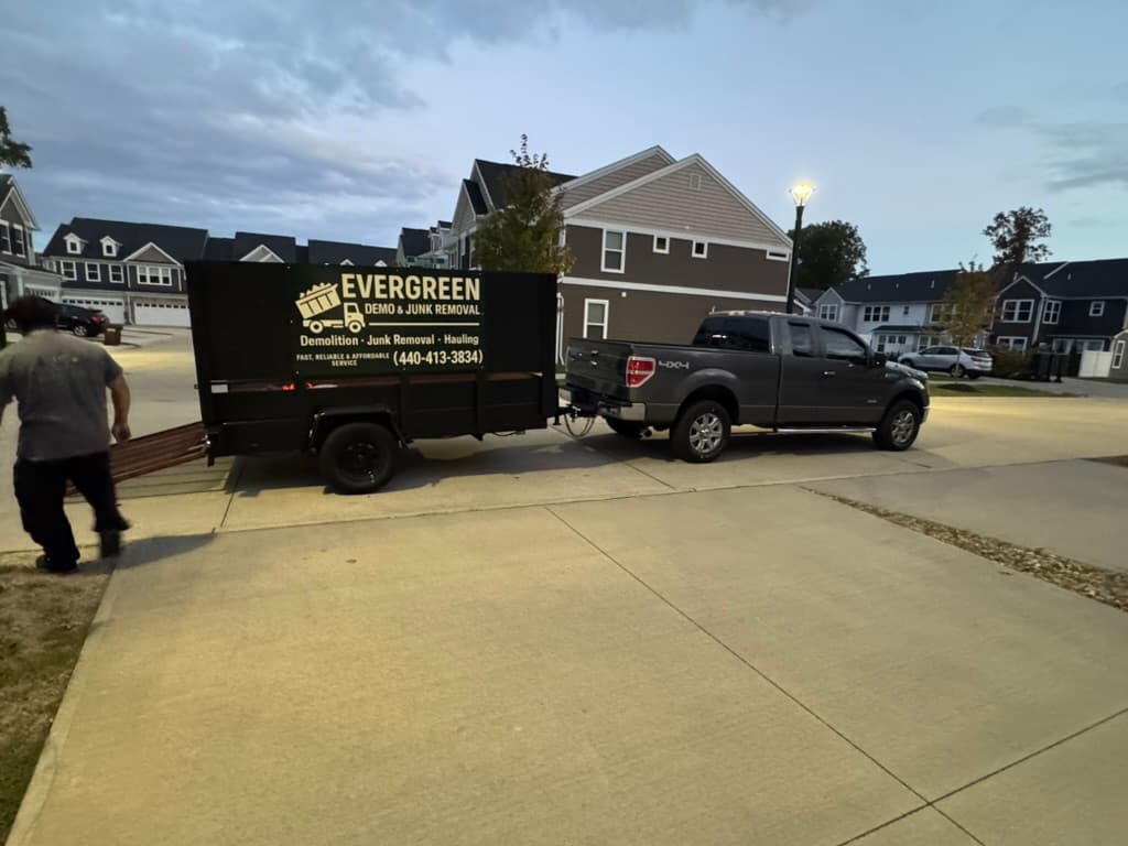 Evergreen Demo & Junk Removal truck and trailer at a residential job in Lake County