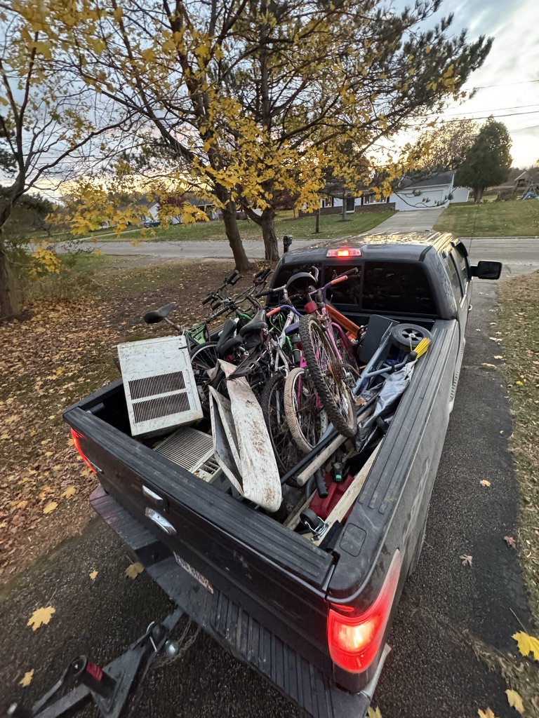 Truck bed loaded with bikes, tools and household junk during removal job