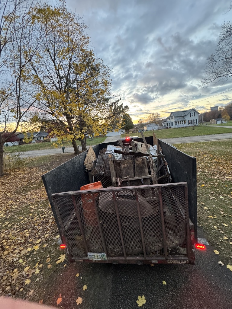 Filled junk removal trailer loaded at dusk after a full-day cleanout job